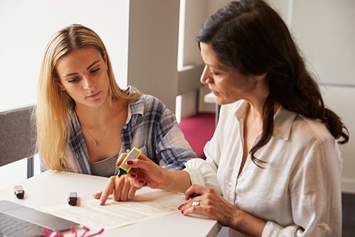 Mother and daughter reviewing college funding documents in June 2025